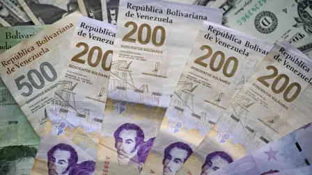Picture of Venezuelan bolivar and US dollar bills taken in Caracas on September 30, 2025. The Venezuelan currency closed September 2025 with a 71% drop against the dollar since January 2, to the distress of millions of families surviving the world's highest inflation, projected by the IMF at 254% by the end of 2025. (Photo by Federico PARRA / AFP)