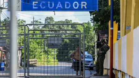 A man speaks with a member of the Ecuadorian Army at the San Miguel International Bridge, closed at the border between Colombia and Ecuador due to the commercial tax dispute between the two countries, on March 19, 2026. Ecuador escalated a month-old trade war with Colombia on February 26, 2026, hiking tariffs on imports from its neighbor to 50 percent over Bogota's alleged failure to combat organized crime along their shared border. (Photo by Luis ACOSTA / AFP)