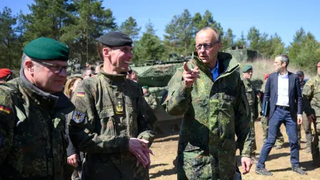German Chancellor Friedrich Merz (R) talks with the Inspector of the Army Christian Freuding (2nd L) as they visit troops of the German armed forces (Bundeswehr) in Munster, northern Germany, on April 30, 2026. (Photo by DANIEL REINHARDT / AFP)