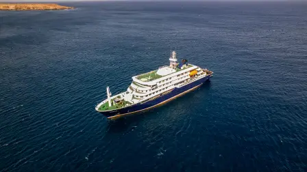 This aerial picture shows a general view of the cruise ship MV Hondius stationary off the port of Praia, the capital of Cape Verde, on May 3, 2026. An outbreak of "severe acute respiratory illness" on board a cruise ship in the Atlantic has left two people dead and a third in intensive care in Johannesburg, South Africa's health ministry told AFP on May 3, 2026.The outbreak occurred on the MV Hondius, travelling from Ushuaia in Argentina to Cape Verde. The patient being treated in Johannesburg tested positive for a hantavirus, a family of viruses that can cause hemorrhagic fever, South African spokesperson Foster Mohale said. (Photo by AFP)