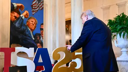 Donald Trump examina un producto en un stand durante una cumbre para pequeñas empresas.