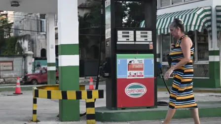 A woman walks past an empty petrol station in Havana on May 13, 2026. The Cuban government, which in early February authorised private fuel imports for the first time in almost 70 years, announced on May 12, 2026 that it will replace the fixed retail price of fuel with a variable price based on import costs. (Photo by YAMIL LAGE / AFP)