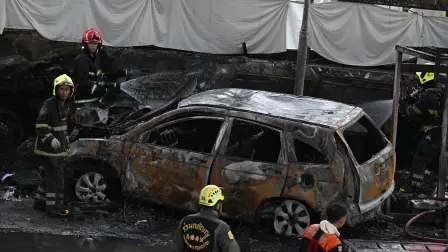 Bomberos y rescatistas rodean la zona afectada por la colisión de un tren con un autobús.