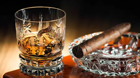 Whiskey and cigar on wooden box close u