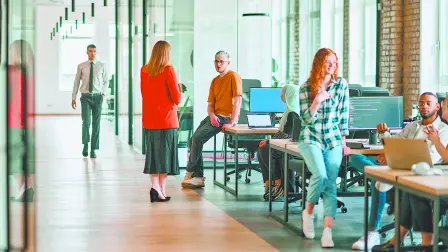 A diverse group of young business individuals congregates in a modern startup coworking center, embodying collaborative innovation and a dynamic atmosphere