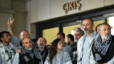 Members of the Global Sumud Flotilla headed for Gaza and arrested and deported by Israel pose outside a terminal following their arrival at Istanbul Airport on May 21, 2026. The first of hundreds of Gaza flotilla activists began arriving at Istanbul airport on may 21  after being arrested then deported from Israel, an AFP correspondent said. The 422 activists, who were flown from southern Israel on three planes chartered by Ankara, had been part of a fleet of around 50 vessels that set sail from southern Turkey on May 14 seeking to break Israel's blockade on Gaza, which was joined at sea by several others. (Photo by Ozan KOSE / AFP)