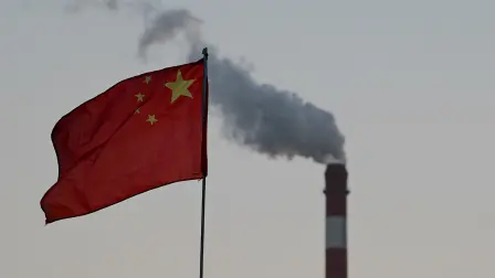 China's national flag flutters in front of a coal-powered power station in Datong, China's northern Shanxi province on November 3, 2021. (Photo by Noel Celis / AFP)