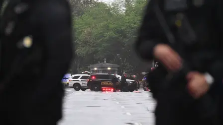 Police vehicles and armed officers are seen near the White House in Washington, DC, on May 23, 2026. Police and security forces swarmed the area around the White House on the evening of May 23 after reports of shots fired, AFP journalists said. US President Donald Trump was at the White House at the time as he worked to negotiate a deal with Iran. (Photo by Alex WROBLEWSKI / AFP)