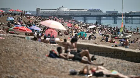 La gente se relaja al sol en la playa de Brighton, en la costa sur de Inglaterra.