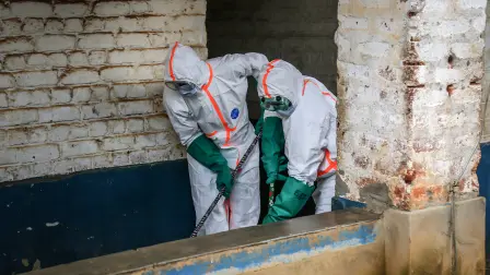 Trabajadores sanitarios con equipos de protección se reúnen para desinfectar la zona de aislamiento para pacientes con ébola en el Hospital General de Referencia de Mongbwalu, en Mongbwalu, , en el este de la República Democrática del Congo.
