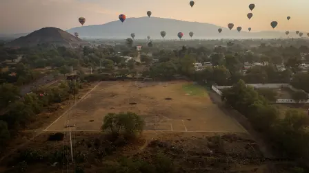 "Estadios desde arrba": Una imagen tomada con un dron muestra un campo de fútbol mientras globos aerostáticos flotan cerca de las pirámides de Teotihuacán.
