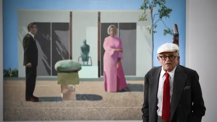 David Hockney posando frente a su obra "Fred and Marcia Weisman" en 2017. Foto: AFP