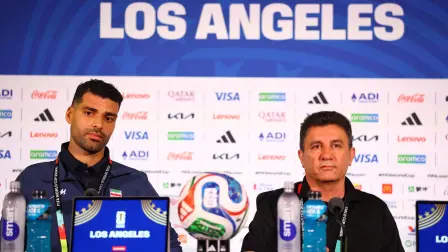 Mehdi Taremi de Irán y el entrenador Amir Ghalenoei durante una conferencia de prensa.