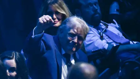 US President Donald Trump gestures alongside First Lady Melania Trump as they attend the "UFC Freedom 250" mixed martial arts event on the South Lawn of the White House in Washington, DC, June 14, 2026. (Photo by Kent NISHIMURA / AFP)