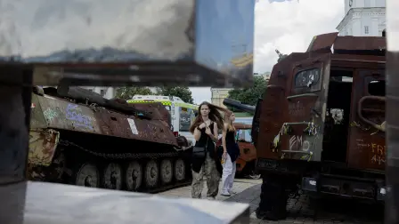 Girls walk past destroyed Russian military equipment at an outdoor exhibition in Kyiv on June 17, 2026, amid the Russian invasion of Ukraine. (Photo by Tetiana DZHAFAROVA / AFP)