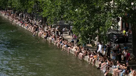 Los bañistas toman el sol a orillas del Canal Saint-Martin mientras Francia sufre una ola de calor en París.
