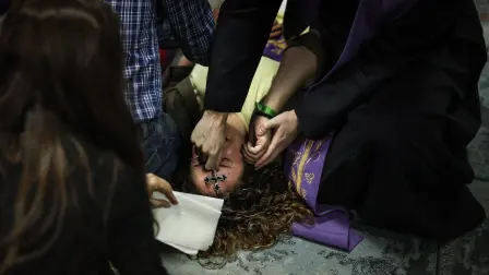 Self-proclaimed priest, not recognized by the Catholic Church, Francisco Marques, 27 years old, places his hands on a womans forehead as she lies on the floor, during a "exorcist retreat" where he claims to cast out demons afflicting his followers, organized by the "Prelature of Saints Peter and Paul in Fatima on May 30, 2026. The scene unfolds not in a church but in the basement of a small shopping centre a short walk from the vast esplanade of Portugal's famed Fatima shine, one of the Catholic Church's most visited pilgrimage sites.The gathering was part of a series of monthly "exorcism retreats" held in Fatima that have raised concerns among Catholic authorities, who say they operate outside official Church oversight by self-styled religious figures and risk exploiting vulnerable believers. (Photo by PATRICIA DE MELO MOREIRA / AFP)