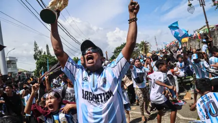 Football fans celebrate Argentina's goal against Algeria as they watch the FIFA World Cup 2026 group J match on a giant screen at Fort Oranje in Ternate, North Maluku, on June 16, 2026. (Photo by AZZAM RIZQULLAH / AFP)