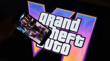 (FILES) This illustration photo created in Los Angeles, December 4, 2023, shows Rockstar Games Grand Theft Auto VI trailer played on a screen in front of the game title. Thirteen years of waiting are about to come to an end: the video game "Grand Theft Auto VI," the latest installment in the saga from US studio Rockstar Games, opens for pre-orders on June 25, 2026, and is poised to become the biggest launch of a cultural product in history. (Photo by Chris DELMAS / AFP)