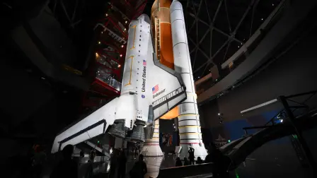 People take pictures underneath NASAs Space Shuttle Endeavour as it stands stacked complete in a launch-ready vertical display with the ET-94 External Fuel Tank and a pair of Solid Rocket Boosters (SRBs) inside the Samuel Oschin Shuttle Gallery at the California Science Center in Los Angeles, on June 24, 2026. The Space Shuttle Endeavour exhibit will open on November 13, 2026 as part of a 200,000-square-foot expansion with the Samuel Oschin Air and Space Center. (Photo by Patrick T. Fallon / AFP)