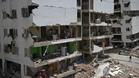 EDITORS NOTE: Graphic content / A view shows heavily damaged apartment buildings with exposed interiors amid rubble in Catia La Mar, La Guaira, Venezuela, on June 26, 2026, following earthquakes. The death toll from two powerful earthquakes that devastated Venezuela earlier this week rose to 920 on June 26, National Assembly President Jorge Rodriguez said. (Photo by Federico PARRA / AFP)