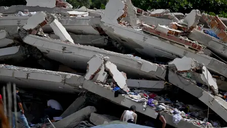 Volunteers and relatives search for possible victims amid the rubble of a collapsed building following earthquakes in Caraballeda, La Guaira state, Venezuela, on June 26, 2026. The death toll from two powerful earthquakes that devastated Venezuela earlier this week rose to 920 on June 26, National Assembly President Jorge Rodriguez said. (Photo by Juan BARRETO / AFP)