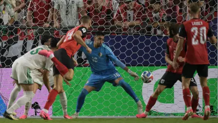 Algeria's goalkeeper #16 Oussama Benbout fails to a goal by Austria's forward #14 Sasa Kalajdzic during the 2026 World Cup Group J football match between Algeria and Austria at the Kansas City Stadium in Kansas City on June 27, 2026.  (Photo by JUAN MABROMATA / AFP)