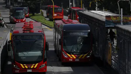 A bus from the TransMilenio public transportation system waits for passengers at a station in Bogota on December 19, 2025. TransMilenio is a bus rapid transit (BRT) system serving Bogota, the capital of Colombia, and the neighboring city of Soacha. The system opened to the public in December 2000. (Photo by Pablo VERA / AFP)