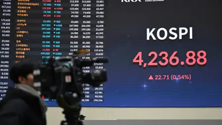 A cameraman films a stock index board showing South Korea's benchmark stock index after a ceremony celebrating the New Year's opening of the South Korea stock market at the Korea Exchange in Seoul on January 2, 2026. (Photo by Jung Yeon-je / AFP)