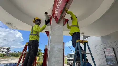 Unos trabajadores aseguran una gasolinera ante la llegada prevista del supertifón Bavi en Saipán, Islas Marianas del Norte