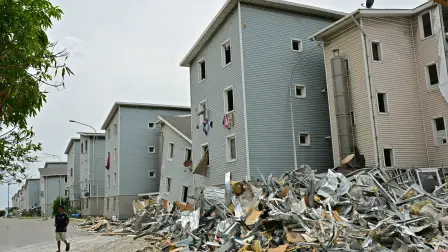 A man walks near rubble at a social housing area in Catia La Mar, La Guaira state, Venezuela on July 9, 2026, following the June 24 twin earthquakes. The United Nations launched an urgent appeal on July 8, 2026 for nearly $300 million towards Venezuela earthquake relief operations as the death toll from the disaster rose to more than 3,800 people. (Photo by MARTIN BERNETTI / AFP)