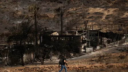 Un hombre pasa junto a una casa calcinada tras un incendio forestal que causó la muerte de al menos 12 personas en Bédar, cerca de Almería.