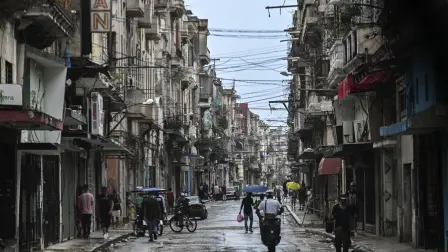 People walk along a street during a nationwide blackout in Havana on July 10, 2026. Cuba suffered its second nationwide blackout in five days on July 10 as twin energy and economic crises, compounded by a six-month US fuel blockade, caused the electricity grid to collapse. (Photo by YAMIL LAGE / AFP)