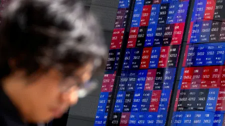 A man walks past an electronic quotation board displaying the Nikkei 225 stock prices on the Tokyo Stock Exchange in Tokyo on June 16, 2026. (Photo by Kazuhiro NOGI / AFP)