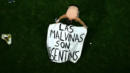 El centrocampista argentino Giovani Lo Celso, ajusta una pancarta con el mensaje "Las Malvinas pertenecen a Argentina" tras ganar el partido de semifinales del Mundial de fútbol de 2026 contra Inglaterra