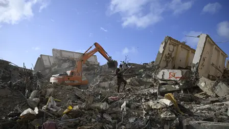 A backhoe loader removes debris at the site of collapsed buildings in Caraballeda, La Guaira state, Venezuela, on July 16, 2026. The death toll from last month's devastating twin earthquakes in Venezuela has surpassed 4,800, while 16,740 people were injured and nearly 21,000 were made homeless the government reported on July 15. (Photo by Federico PARRA / AFP)