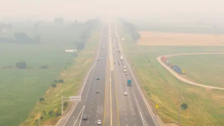 Vehículos circulan por la autopista 401 mientras el humo de los incendios forestales del noroeste de Ontario llena el cielo en Thames Centre.
