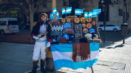 Un vendedor ofrece banderas y recuerdos de Argentina en una calle de Buenos Aires, donde el fútbol, la identidad nacional y la vida urbana se encuentran.