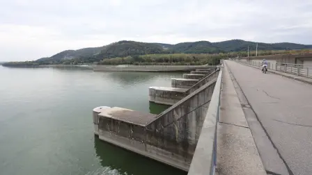 Un hombre monta en bicicleta sobre la central hidroeléctrica Greifenstein de Verbund durante un período de niveles de agua históricamente bajos en el río Danubio.