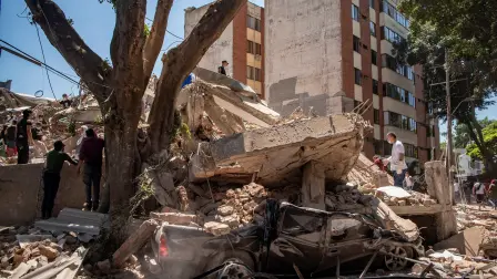 Residents dig through debris by a crushed car and a collapsed building after an earthquake, in Cali, Colombia, August 10, 2026. REUTERS/Christian EscobarMora