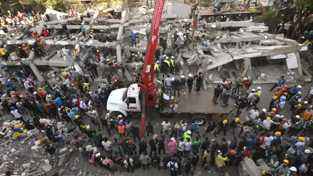 Rescatistas y voluntarios buscan sobrevivientes entre los escombros de un edificio derrumbado tras un terremoto en Cali.