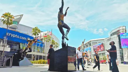 LOS ANGELES, CALIFORNIA - AUGUST 12: People gather near a statue of Kareem Abdul-Jabbar outside Crypto.com Arena, home of the NBA's Los Angeles Lakers, on August 12, 2026 in Los Angeles, California. Los Angeles Lakers owner Mark Walter is reportedly selling the Lakers to venture capitalist Joshua Kushner, brother of President Trump's son-in-law Jared Kushner, and former Disney CEO Bob Iger for a record $12.5 billion.   Mario Tama/Getty Images/AFP (Photo by MARIO TAMA / GETTY IMAGES NORTH AMERICA / Getty Images via AFP)