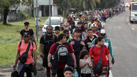 Migrants walk along the highway as part of a caravan seeking to reach the Mexican capital in Tapachula, Chiapas State, Mexico, on October 1, 2025. A caravan of some 1,500 migrants of various nationalities left southern Mexico on Wednesday for the nation's capital to demand papers that would allow them to regularize their status. (Photo by Jose TORRES / AFP)