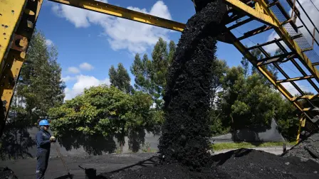 A miner stands as a machine drops coal rocks at the Mineria LyC coal mine in Tausa, Cundinamarca Department, Colombia on August 20, 2025. Colombian President Gustavo Petro issued a second decree on August 30, 2025 to try to halt coal exports to Israel, following a first attempt in 2024, in rejection of the military offensive in the Gaza Strip, and which specifies that the ban will be without exceptions this time and will apply under any circumstances starting this date, the Presidency said in a statement. (Photo by Raul ARBOLEDA / AFP)