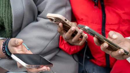 Estudiantes miran sus teléfonos móviles antes de que comience la clase.