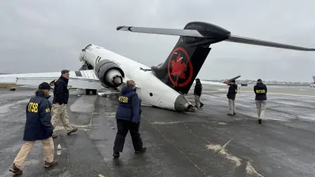 Investigadores de la NTSB inspeccionan los restos de un avión de Air Canada Express en el aeropuerto LaGuardia de Nueva York.