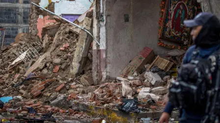 A State Police officer walks amid remains caused by a car bomb explosion outside the municipal police station in Ojocaliente, Zacatecas, Mexico, on August 31, 2026. A car bomb exploded on August 30 night in front of a police station in Mexico, wounding six people, authorities said. The attack took place in the state of Zacatecas, which has key routes for drug trafficking. (Photo by Jess Mireles / AFP)
