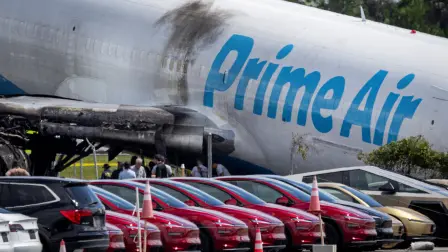 Tesla cars are parked in a lot next to where a crashed Amazon Prime Air cargo plane came to rest, where airport officials said it overran a runway at Miami International Airport, in Miami, Florida, U.S., September 7, 2026. REUTERS/Marco Bello