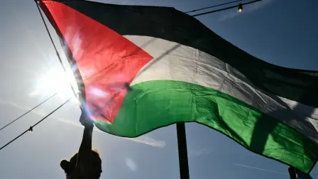 A person waves a Palestinian flag as people from Venice4Palestine, Global Sumud Italia, arrive on a boat during an event in support of Gaza, on the sidelines of the 83Rd Venice Film Festival at Venice Lido on September 7, 2026. (Photo by Stefano RELLANDINI / AFP)