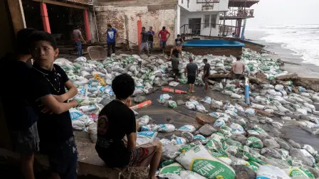 Residents place sandbags as a protective barrier against strong waves generated by Hurricane Polo at Playa Azul, in the municipality of Lazaro Cardenas, Michoacan, Mexico, on September 23, 2026. Hurricane Polo strengthened to the highest category on September 22 in the Mexican Pacific, with no forecast of making landfall but with heavy rainfall expected. Polo intensified from Category 1 to Category 5 on the Saffir-Simpson scale in less than 24 hours. (Photo by Enrique Castro / AFP)